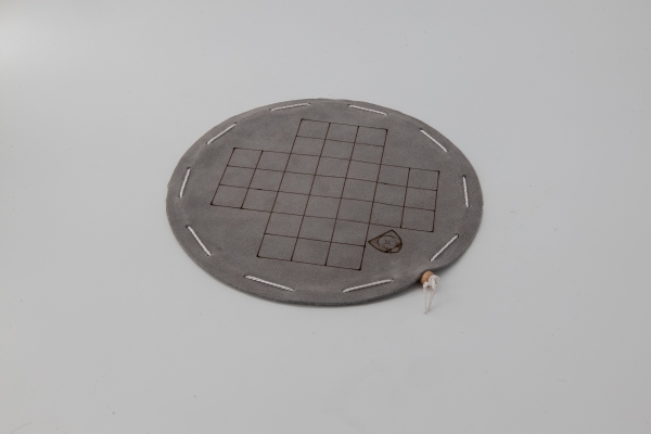 Fox and geese board game on a round gray leather playing field